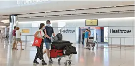  ?? (AFP) ?? Passengers walk through the arrivals hall after landing at London Heathrow Airport in west London