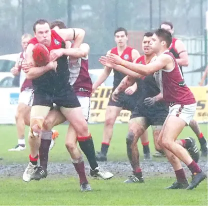  ??  ?? Steady rain all day made for tough and tight in close battles for the ball when Warragul and Traralgon clashed at Western Park on Saturday, Gull Matt Moseley using his strength to try to break free of a Traralgon tackle in a game the Gulls fell short by 27 points but held their place in the “five”.