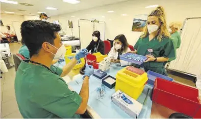  ?? MANOLO NEBOT ?? Un grupo de sanitarios prepara las dosis de la vacuna contra el covid-19 hace unos días en el Auditori de Castelló.