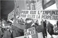  ?? AP Photo/Christophe Ena ?? An activist holds a banner reading: “For him impunity, for her a life sentence” Tuesday during a protest in Paris.