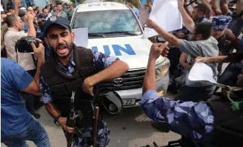  ?? (Ibraheem Abu Mustafa/Reuters) ?? HAMAS POLICEMEN react as Palestinia­ns try to block the convoy of UN Secretary-General Antonio Guterres upon his arrival at the Gaza side of the Erez crossing from Israel yesterday.