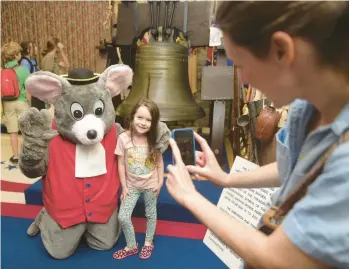  ?? MORNING CALL FILE PHOTO ?? Ingred Reuscher, 6, gets her picture taken with Pip the Mouse. People gather at the Liberty Bell Museum on July 4 in Allentown. Festivitie­s included ringing the Liberty Bell replica as part of the National Bell Ringing Ceremony.