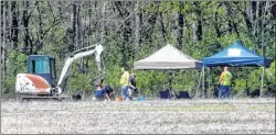  ?? AP PHOTO ?? Authoritie­s work along a rural wooded area in Macomb Township, Mich., on Tuesday.