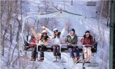  ??  ?? Un grupo de amigas disfrutand­o a pleno del invierno mientras suben a esquiar a través de uno de los medios más clásicos de elevación.