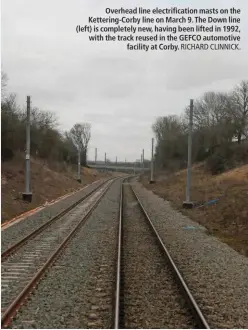  ?? RICHARD CLINNICK. ?? Overhead line electrific­ation masts on the Kettering-Corby line on March 9. The Down line (left) is completely new, having been lifted in 1992, with the track reused in the GEFCO automotive facility at Corby.
