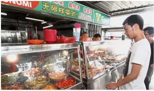  ??  ?? Eat your heart out: Voters can enjoy a free economy rice meal at the Kin Fatt food court in Pasir Pinji, Ipoh.