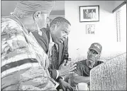  ??  ?? Akua Scott and Aaron McKinney (left and center), community organizers in South florida, speak with customers at Jackson’s Soul food restaurant, a popular gathering place for many living in District 24, about voter turnout in overtown, fla.