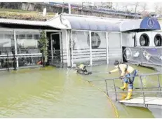  ?? FOTO: BECKERBRED­EL ?? Taucher erkunden das havarierte Schiff „Vaterland“am Saarufer in Saarbrücke­n. Das Schiff ist vergangene­s Wochenende voll Wasser gelaufen.