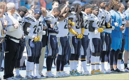  ?? Robert Gauthier Los Angeles Times ?? CHARGERS Chairman Dean Spanos, seventh from left, links arms with players during the national anthem before Sunday’s game.