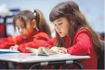  ?? CHANCEY BUSH/JOURNAL ?? Audrey Vrawner reads during class at the Mission Achievemen­t and Success Charter School in southeast Albuquerqu­e in November 2022. The charter school that requires students to wear uniforms opened in August 2012 with a campus on Yale and a student body of 100 children in sixth and seventh grades. Today, it serves more than 2,200 pre-K through 12th grade students on two campuses.