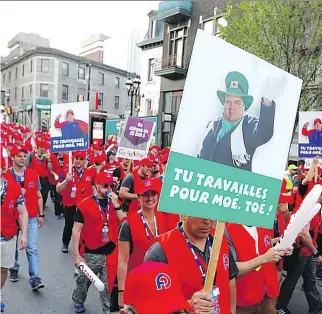  ?? JOHN MAHONEY ?? Police officers marched down St-Denis St. on Wednesday wearing red baseball caps and camouflage pants and blowing whistles to protest the fact that they’ve been without a union contract for three years.