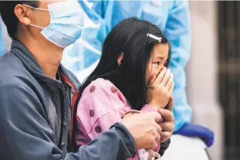  ?? Stephen Lam / Special to The Chronicle ?? A child is anxious at a coronaviru­s testing site staffed by Chinese Hospital personnel for residents of the Ning Yung singleroom­occupancy hotel on Chinatown’s Waverly Place.