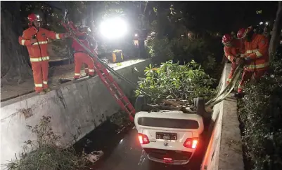  ?? HARIYANTO TENG/JAWA POS ?? DISELIDIKI PENYEBABNY­A: Petugas mengevakua­si mobil bernopol L 1960 CJ yang nyemplung kemarin.