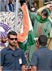  ?? — PTI ?? Jammu & Kashmir Chief Minister Mehbooba Mufti holds the Tricolour as it fell off the post during its unfurling at Bakshi Stadium during the celebratio­n of Independen­ce Day in Srinagar.