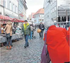  ?? FOTOS: CORINNA KONZETT ?? Kleidung, Gürtel oder Süßigkeite­n: Beim Fastenmark­t in Leutkirch ist für jeden etwas dabei. „Ich putz’ sie alle rein“, singt Helmut Göttlich, der für sauberes Schuhwerk sorgt.