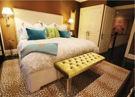  ??  ?? A faux leopard rug and grasscloth wallpaper help set a serene tone in the master bedroom retreat.