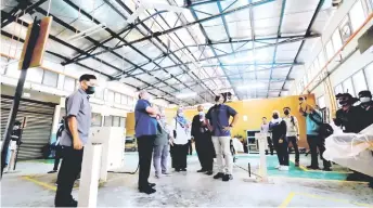  ?? — Bernama photo ?? Radzi (sixth le ) inspects the conditions of a building at Langkawi Vocational College.