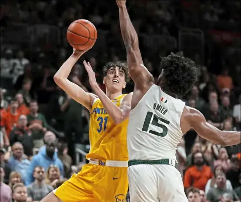  ?? Rebecca Blackwell/Associated Press ?? Jorge Diaz Graham, left, shoots over Miami defender Norchad Omier Saturday in Coral Gables, Fla.