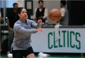  ?? AP Photo/Charles Krupa ?? ■ Boston Celtics assistant coach Kara Lawson passes the ball at the team’s training facility in Boston. Celtics guard Gordon Hayward said Lawson has already made her presence felt. “She’s been good as far as just the experience she has as a basketball player,” Hayward said. “Having somebody that well-versed in basketball, that experience­d is good.”