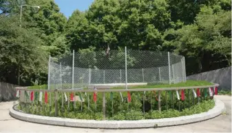  ??  ?? TOP: The base of where the Christophe­r Columbus statue in Grant Park stood is fenced off on Friday. ABOVE: A fenced-off area Friday around what is left of a Columbus monument in Arrigo Park in Little Italy.