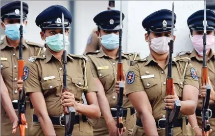  ?? AFP ?? Sri Lankan police women wearing facemask as a preventive measure against the spread of the Covid-19 coronaviru­s take part in a rehearsal parade in Colombo on Wednesday. With the number of global coronaviru­s infections shooting past 200,000, government­s announced new containmen­t measures and the US Congress approved a $100 billion emergency relief package.
