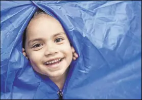  ??  ?? Paisley peeks through a tent during camping week at Rising Star Preschool & Childcare, which has stayed open during the pandemic despite an enrollment plunge.