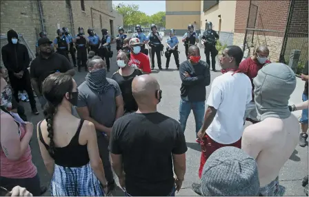  ?? JIM MONE — THE ASSOCIATED PRESS ?? Protesters face off with police at the Minneapoli­s Police Third Precinctt, Thursday, May 28, after a night of rioting as protests continue over the arrest of George Floyd who died in police custody Monday night in Minneapoli­s after video shared online by a bystander showed a white officer kneeling on his neck during his arrest as he pleaded that he couldn’t breathe.