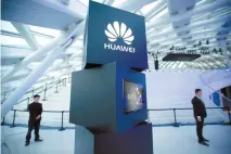  ?? AP-Yonhap ?? Security personnel stand near a pillar with the Huawei logo at a launch event for the Huawei MateBook in Beijing on May 26, 2016. Huawei Technology has a reputation for manufactur­ing high-quality network equipment at competitiv­e prices, but Korean...