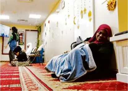  ?? PHOTOS BY SOPHIE PARK FOR THE BOSTON GLOBE ?? Dananai Morgan, 38, fed her 2-month-old son, Muneni Morgan, during evening prayers at the Mosque for Praising Allah in Boston on Tuesday.