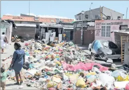  ?? PICTURE: MLONDOLOZI MBOLOA ?? Rubbish blocks Khosi Street and Freedom Way in Joe Slovo, Milnerton. Residents accuse the city of failing to provide an adequate refuse removal service.
