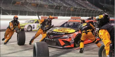  ?? (AP/Brynn Anderson) ?? Martin Truex Jr. takes a pit stop during Wednesday’s NASCAR Cup Series race at Darlington, S.C. It was the first Cup Series race on a Wednesday in 36 years and was the first of 20 events scheduled in seven Southern states through June 21.