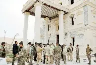  ??  ?? Soldados sirios se reúnen frente a un palacio en Palmira.