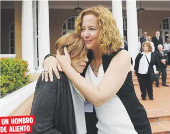  ??  ?? Sara Rosario, a la derecha, abraza y consuela a Sara Lugo, viuda de Cardona, durante el recibimien­to en la Casa Olímpica. UN HOMBRO DE ALIENTO