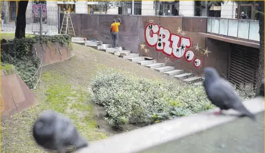  ?? Elisenda Pons ?? Un operario limpia una serie de grafitis en la plaza de la Vila de Madrid, el pasado miércoles.