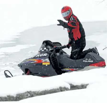  ?? CLIFFORD SKARSTEDT/EXAMINER FILES ?? A snowmobile­r makes his way onto Chemong Lake off the James A. Gifford Causeway in Bridgenort­h on Jan. 3, 2015. The Ontario Provincial Police is urging local snowmobile­rs not to drink and drive and to dress properly for the season, with a wind chill of...