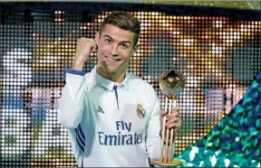  ?? KIM KYUNG-HOON /REUTERS ?? Cristiano Ronaldo poses with the Golden Ball trophy after his hat-trick helped Real Madrid overcome the Kashima Antlers 4-2 after extra time in Sunday’s FIFA Club World Cup final at Internatio­nal Stadium in Yokohama, Japan.