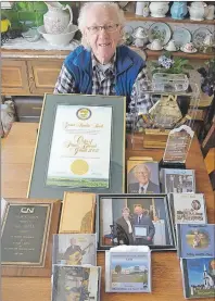  ?? SALLY COLE/THE GUARDIAN ?? Garnet Buell, 84, shows some of his awards and other mementos from a life spent in the service of others. Of special interest are the Order of Prince Edward Island, which he received in 2008, and a metal clock he got after retiring from Canadian...