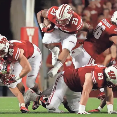  ?? MARK HOFFMAN / MILWAUKEE JOURNAL SENTINEL ?? Wisconsin running back Jonathan Taylor finds a seam in the Western Kentucky defense during the first half Friday night at Camp Randall Stadium.