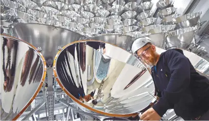  ?? AP-Yonhap ?? Engineer Volkmar Dohmen stands in front of xenon short-arc lamps in the DLR German national aeronautic­s and space research center in Juelich, western Germany, Tuesday. The lights are part of an artificial sun that will be used for research purposes.