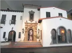  ?? Mel Melcon Los Angeles Times ?? ARTIST Chris Toledo peers through the front door of Casa California. His miniature 1920s Spanish Mediterran­ean house is under 6 feet wide.