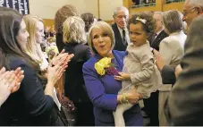  ??  ?? Lujan Grisham carries her granddaugh­ter Avery Stewart, 3, following the delivery of her State of the State address.