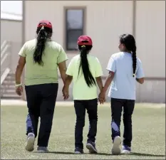  ?? AP file photo ?? Immigrants seeking asylum hold hands as they leave a cafeteria last August at the ICE South Texas Family Residentia­l Center in Dilley, Texas. The isolation of at least three families at the U.S. Immigratio­n and Customs Enforcemen­t’s detention center in Dilley has raised new fears of the coronaviru­s spreading through a facility that has long been accused of providing substandar­d medical care.