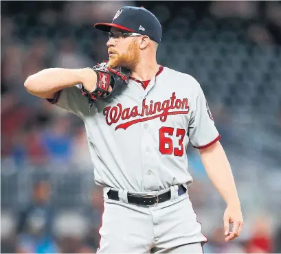  ?? TODD KIRKLAND GETTY IMAGES FILE PHOTO ?? Sean Doolittle of the Nationals put lavender oil on the leather laces around the webbing of his glove for the 2019 post-season.