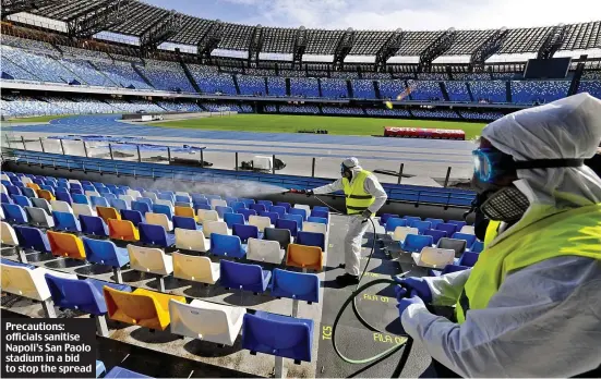  ??  ?? Precaution­s: officials sanitise Napoli’s San Paolo stadium in a bid to stop the spread