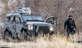  ?? NEWS PHOTO RYAN MCCRACKEN ?? Members of law enforcemen­t investigat­e a situation near the bottom of Scholten Hill on Monday.