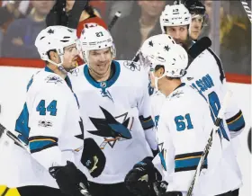  ?? Jeff McIntosh / Associated Press ?? Joonas Donskoi celebrates his third-period goal against the Flames with Sharks teammates Marc-Edouard Vlasic (44) and Justin Braun (61).