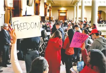  ?? PHOTO BY BOB ANDRES/ATLANTA JOURNAL-CONSTITUTI­ON VIA AP ?? Protesters opposed to a proposed abortion bill fill a Georgia state capitol hallway Monday in Atlanta. A Georgia Senate committee approved a measure that would ban most abortions once a fetal heartbeat can be detected.