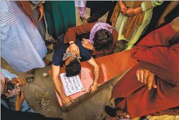  ?? Marcus Yam Los Angeles Times ?? A MAN weeps over the casket of Farzad Ahmadi, 12, one of seven children killed in an explosion in Kabul.