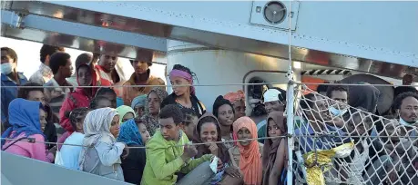  ??  ?? In porto Un gruppo di profughi e migranti aspetta sulla nave Chimera della Marina di poter scendere nel porto di Augusta, vicino Siracusa