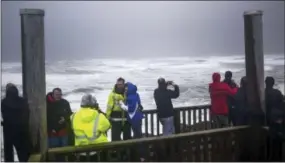  ?? DANNY MILLER — THE DAILY ASTORIAN VIA AP ?? Park visitors take photos from atop a viewing deck overlookin­g the South Jetty of the Columbia River as a storm rolls in on Saturday at Fort Stevens State Park in Hammond, Ore.